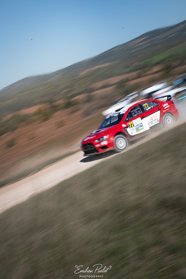 Mitsubishi Lancer rouge et blanche n°77 en filé sur un chemin de montagne