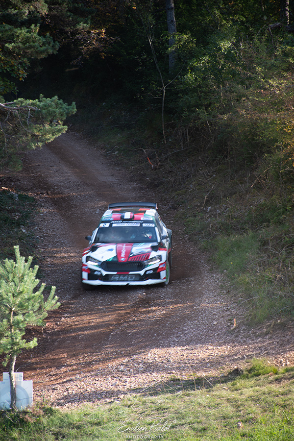 Skoda Fabia Rally2 blanche, rouge et verte descendant un chemin forestier