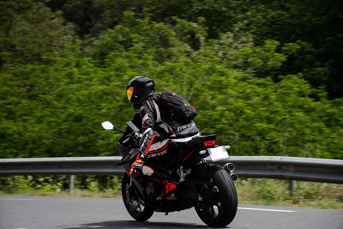 Motard penché en virage sur route de montagne