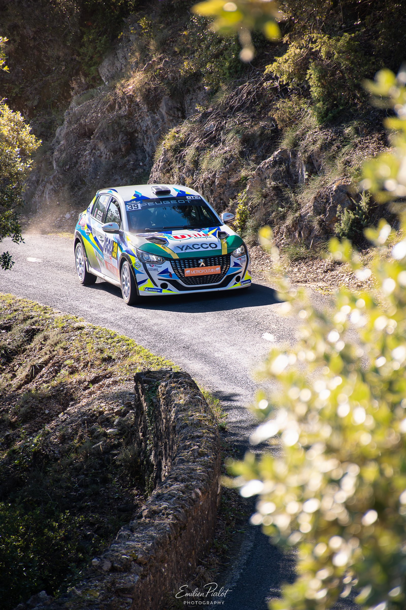 Équipe d'assistance autour d'une Citroën C3 Rally2 IGOL, capot et hayon ouverts, roue démontée
