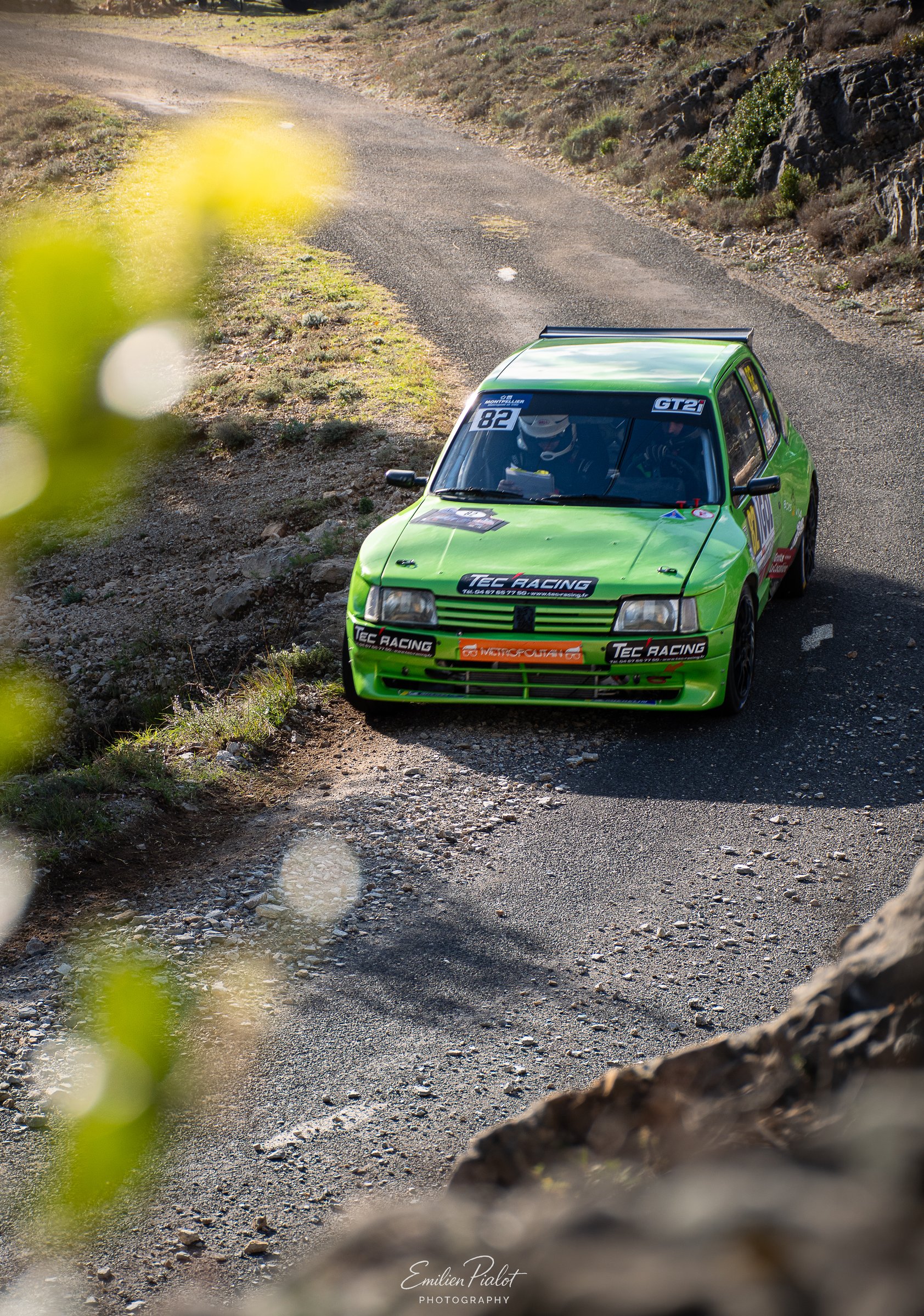 Filé de vitesse d'une voiture de rallye orange et grise sur route de montagne