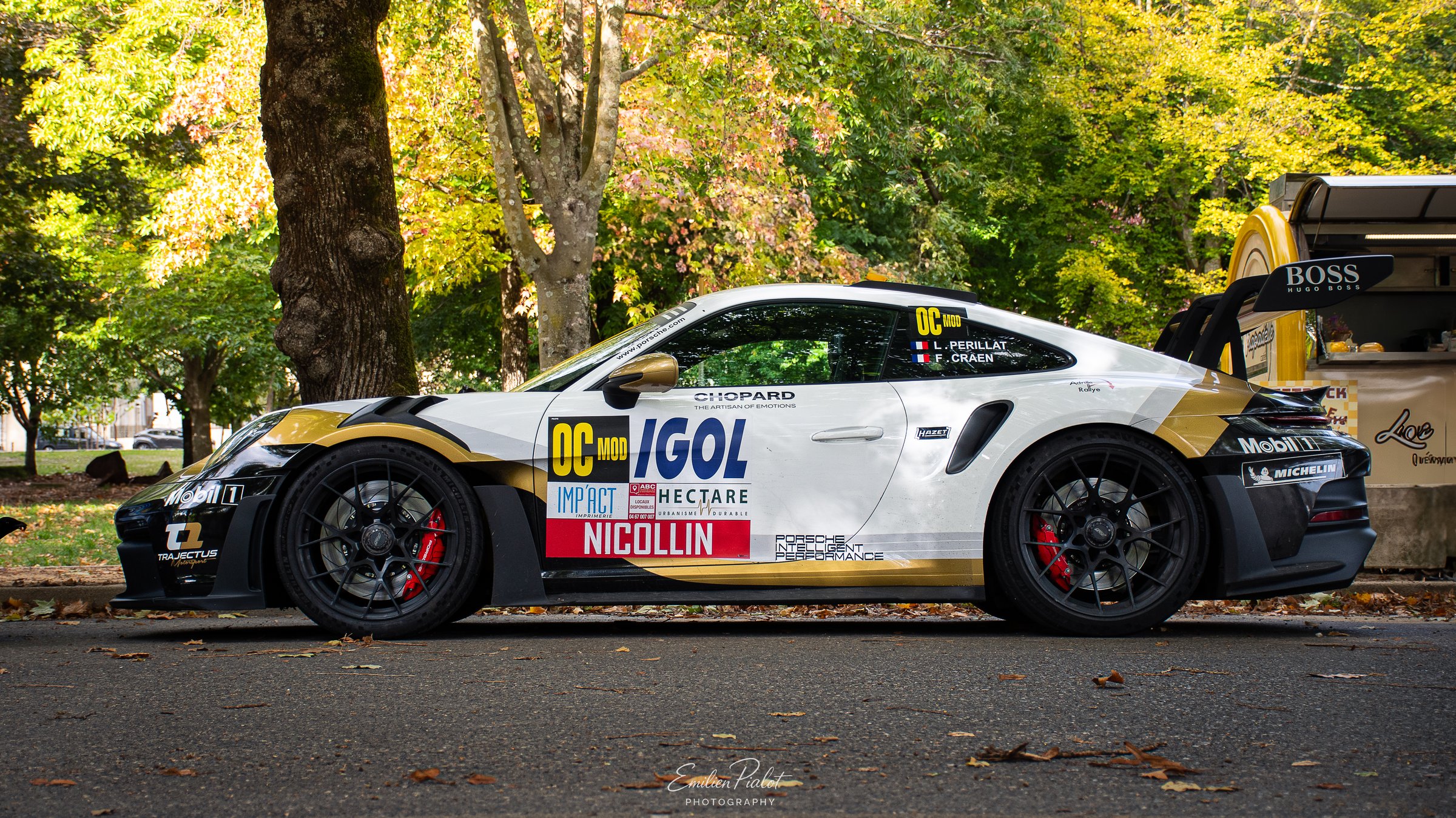 Alpine A110 Rally jaune et noire IGOL dans le parc, assistance en arrière-plan