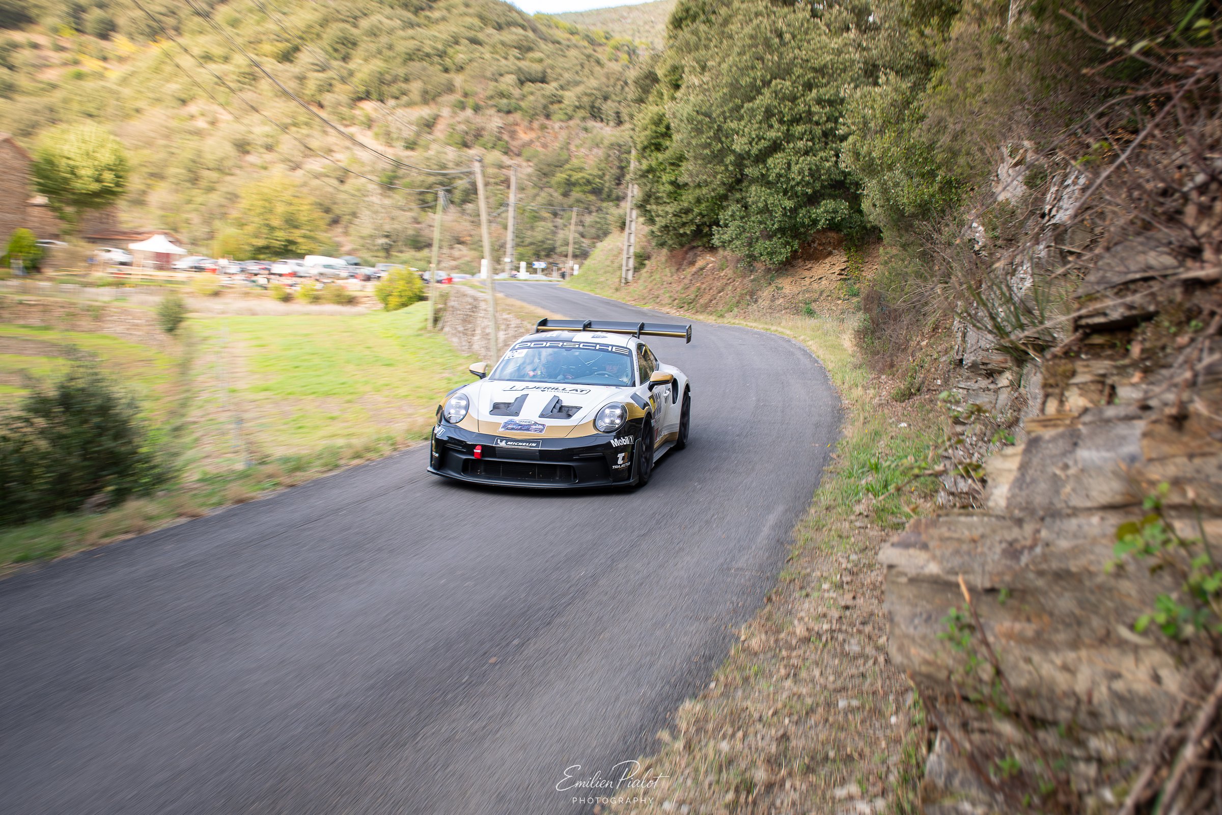 Porsche 911 GT3 Rally gris et noir sur route de montagne, vallée en arrière-plan