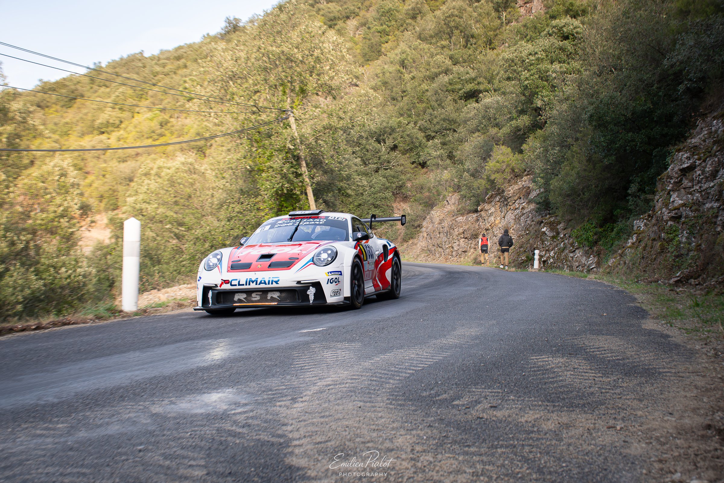 Porsche 911 GT3 Rally blanche et rouge au freinage, falaise en arrière-plan