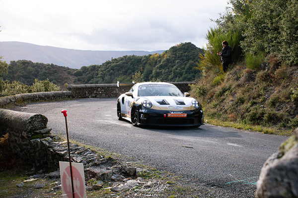 Porsche 911 blanche et or dans le même virage de montagne