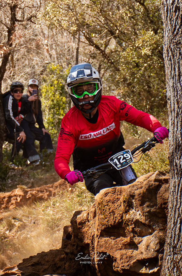 Pilote de VTT descente en action dans les sous-bois de Millau