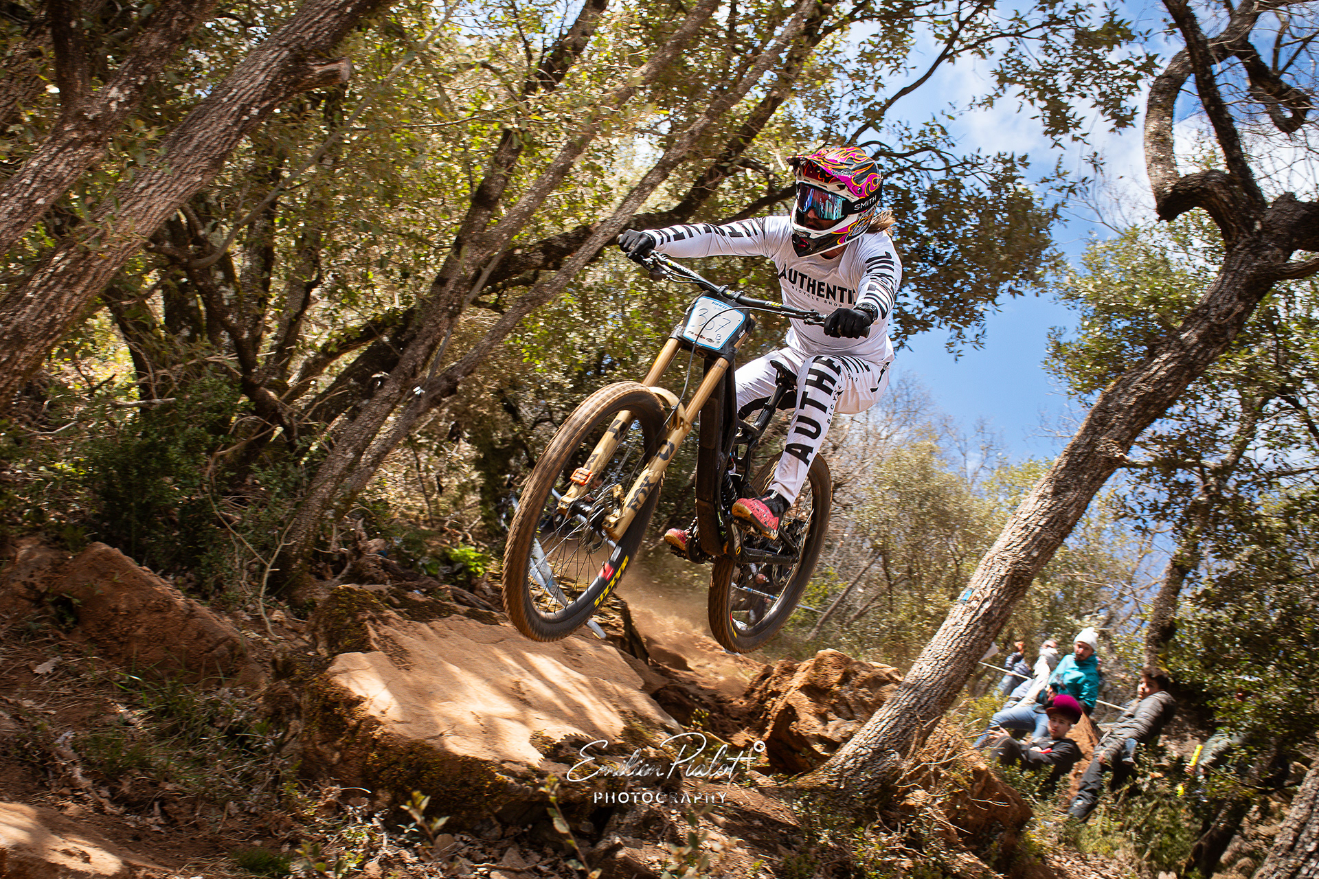 Pilote de VTT descente en plein saut, spectateurs en contrebas, Millau