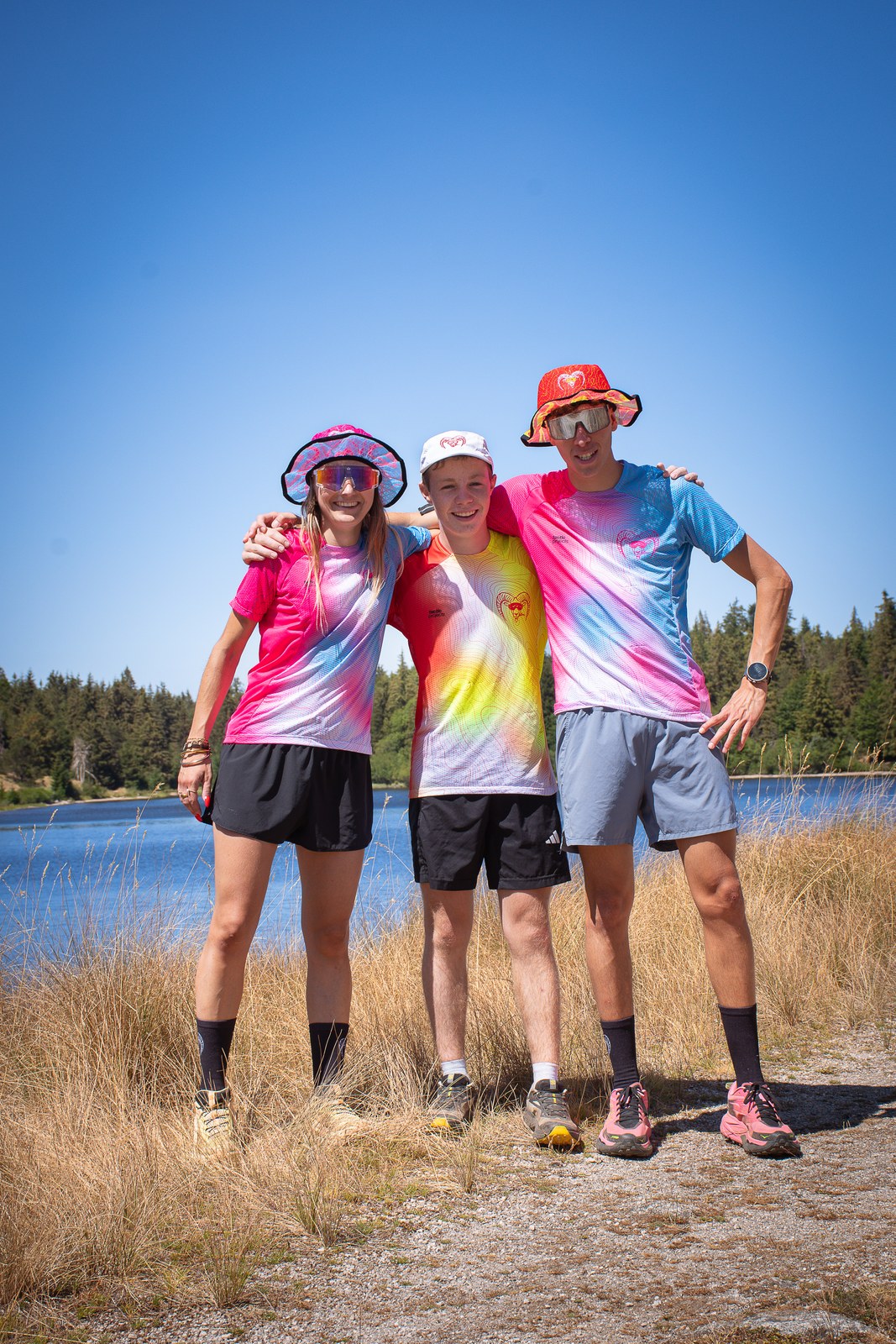 Trio enlacé au bord du lac, tenues tie-dye