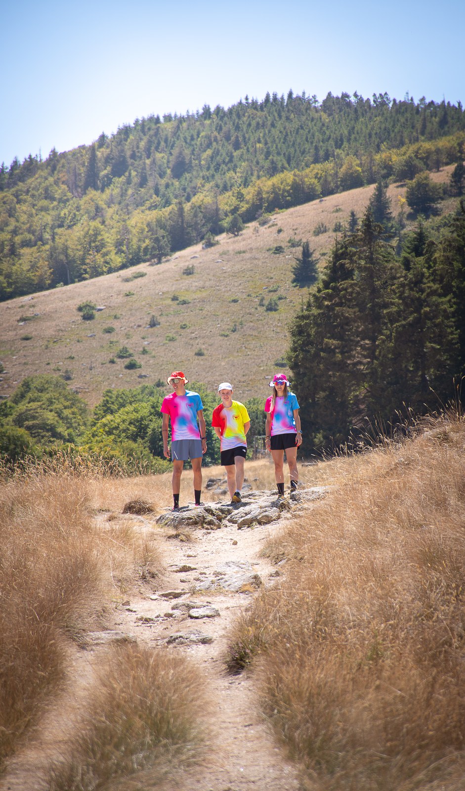 Groupe marchant sur un sentier de crête, au loin