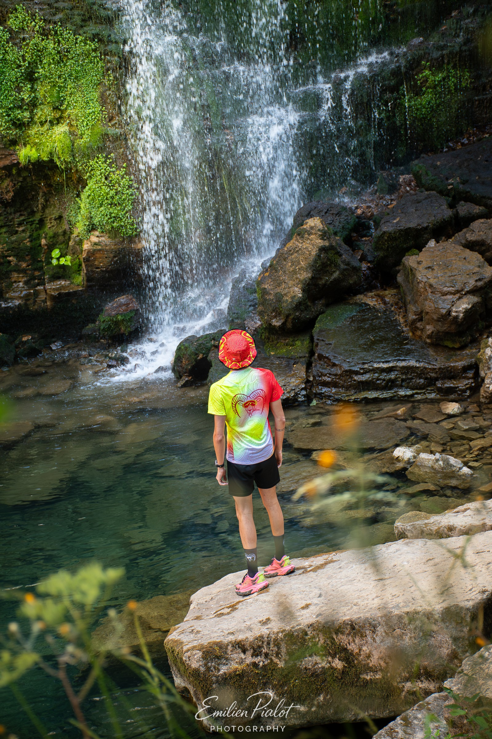 Séance Muflon devant la cascade, casquette jaune et rouge