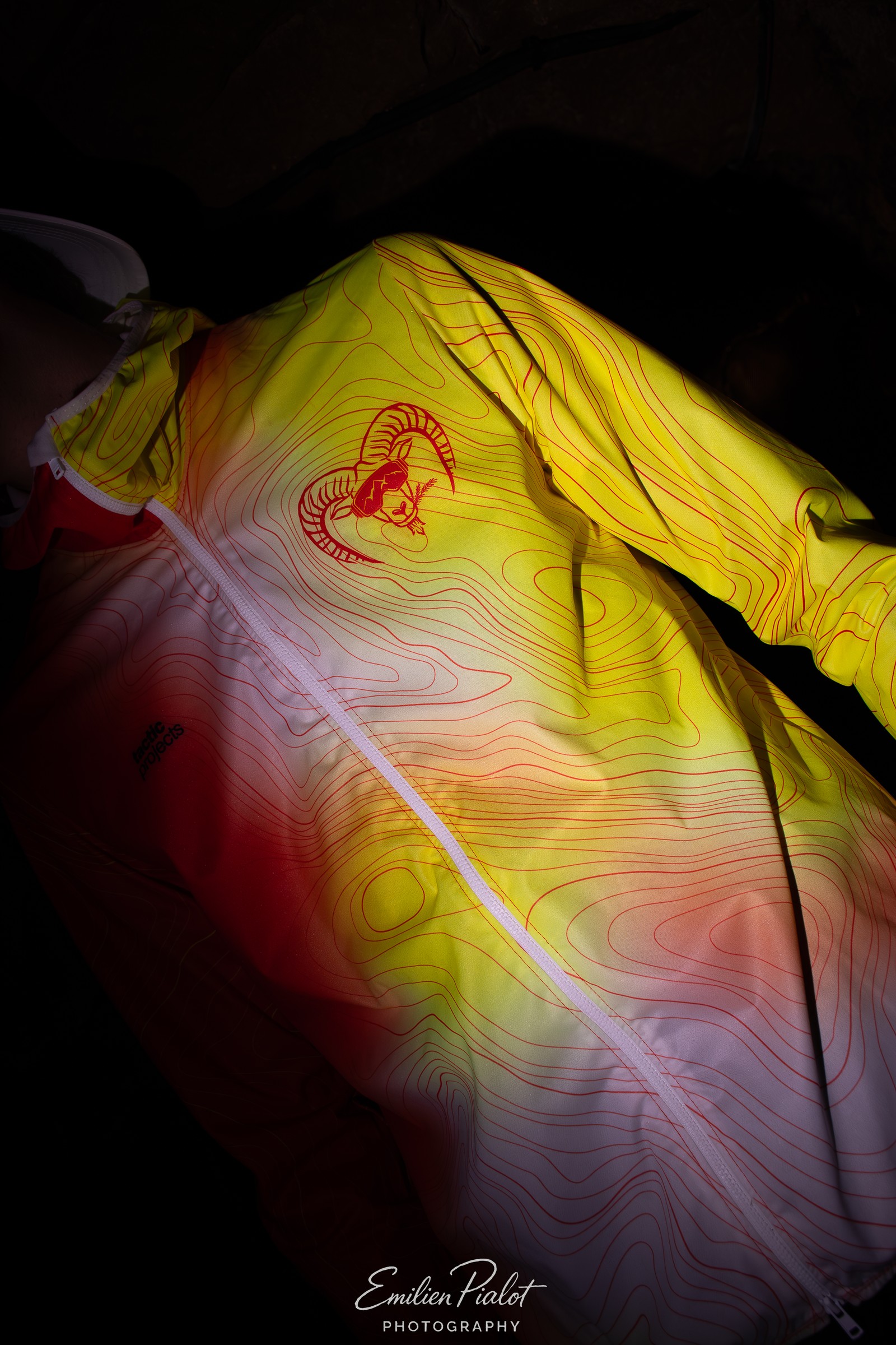 Détail de la veste technique jaune Muflon, éclairage dramatique