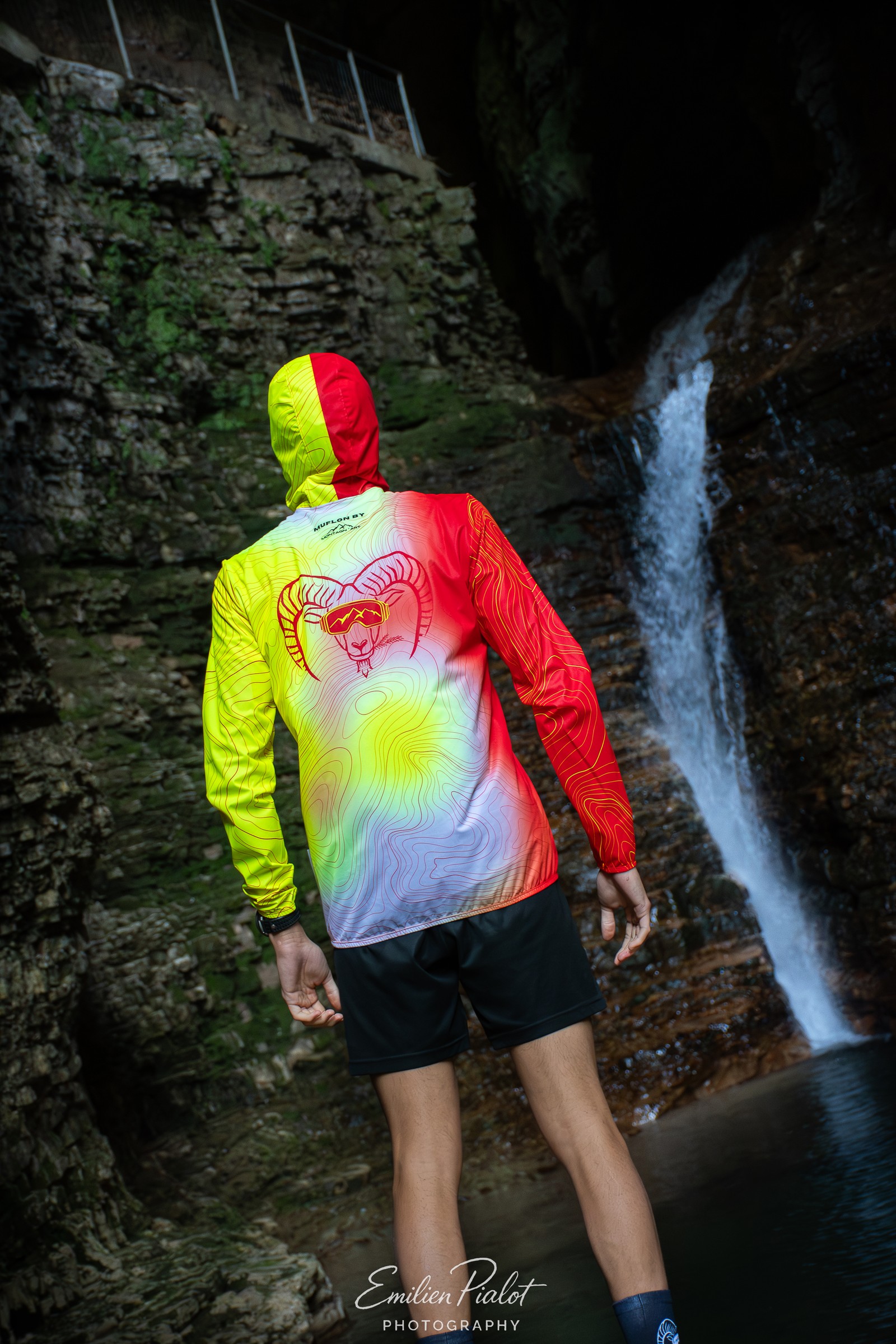Séance Muflon devant la cascade, vue de dos, veste rouge et jaune